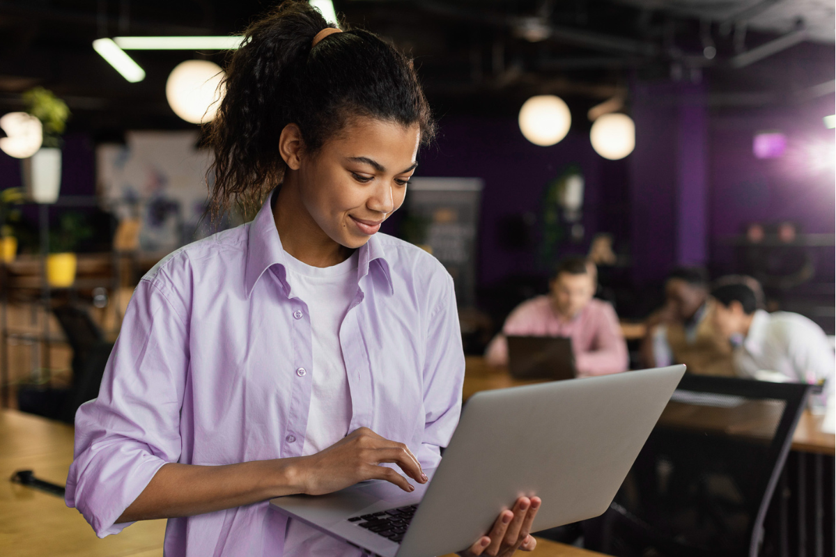 Empreendedora lendo artigo em seu notebook sobre Revenda de software ou franquia: qual é a melhor opção para empreender em TI.