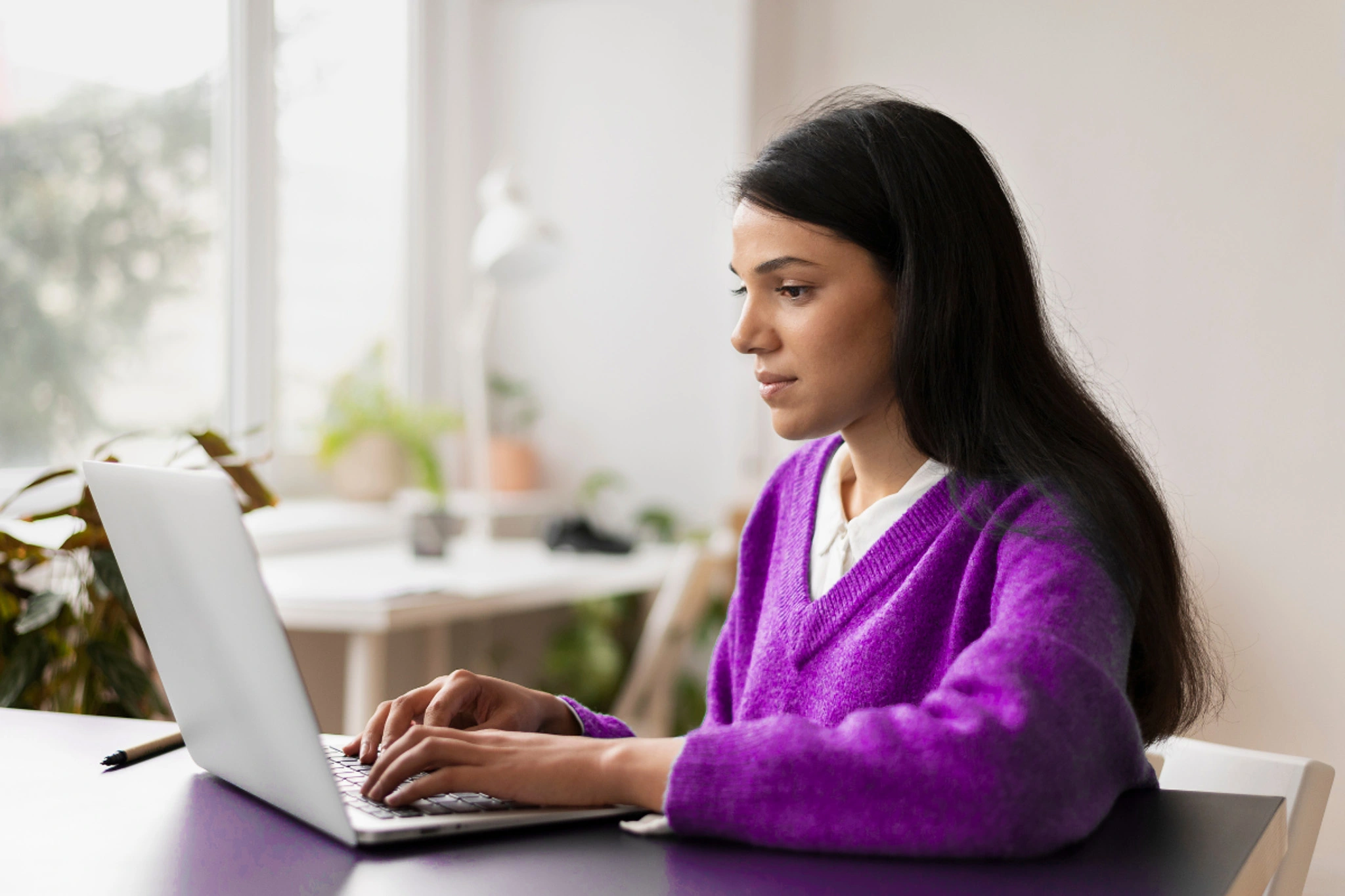 Revendedora de software GestãoClick lendo artigo no notebook sobre: Quais são os requisitos para se tornar um Parceiro VIP GestãoClick?