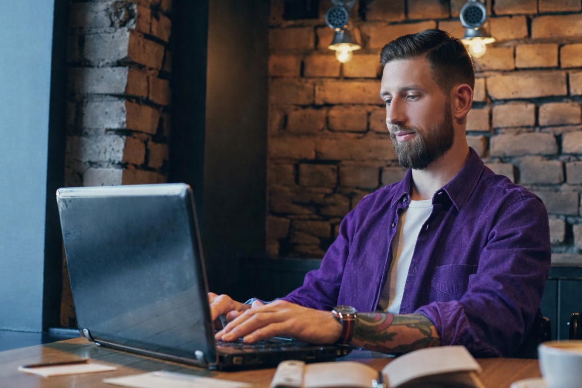 Homem profissional trabalhando em um notebook sobre uma mesa em um ambiente de escritório representando: Autuação fiscal em 2026: o que levar em consideração com a Reforma Tributária.