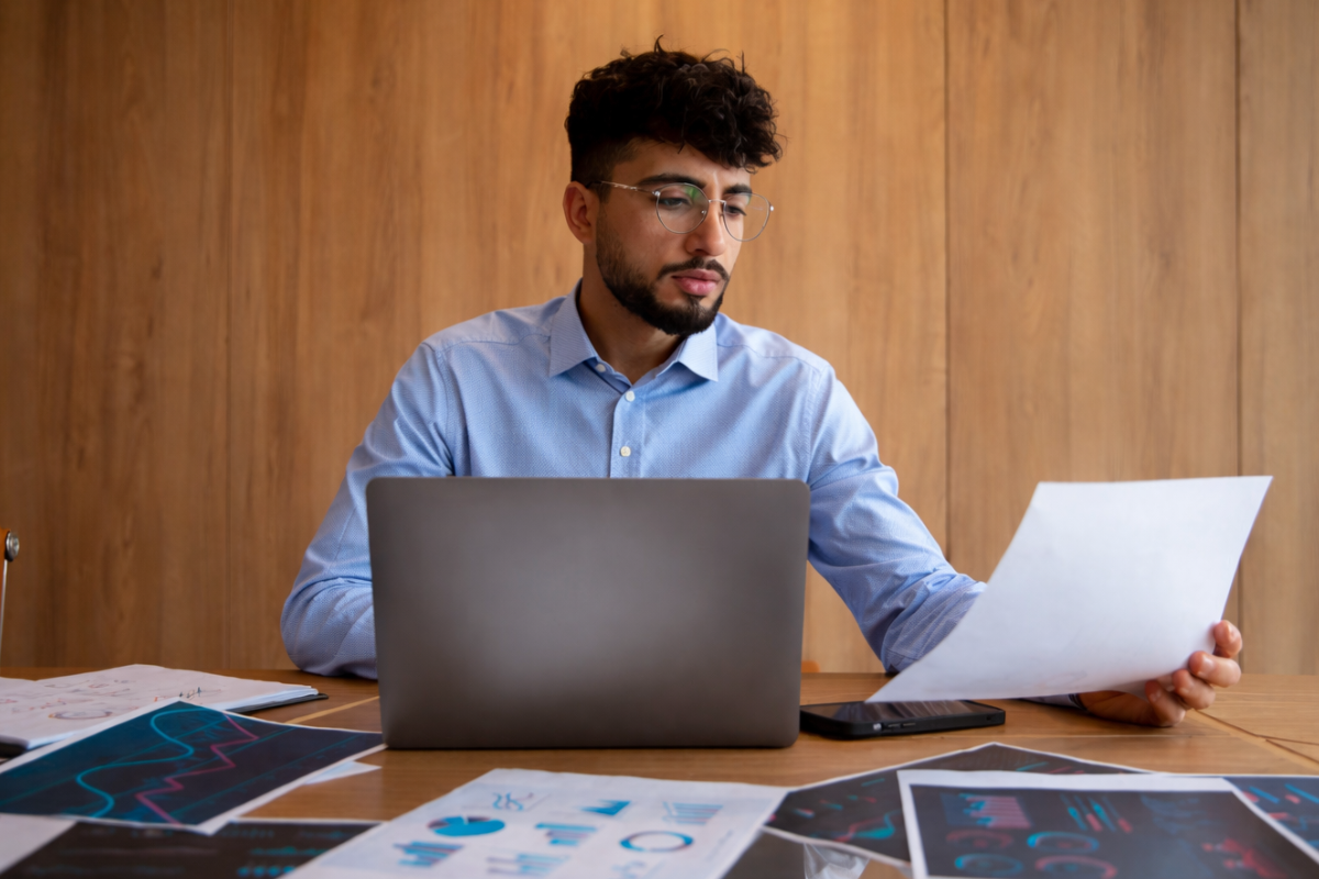 Homem profissional trabalhando em um notebook sobre uma mesa em um ambiente de escritório representando: ERP é obrigatório para microempresa?
