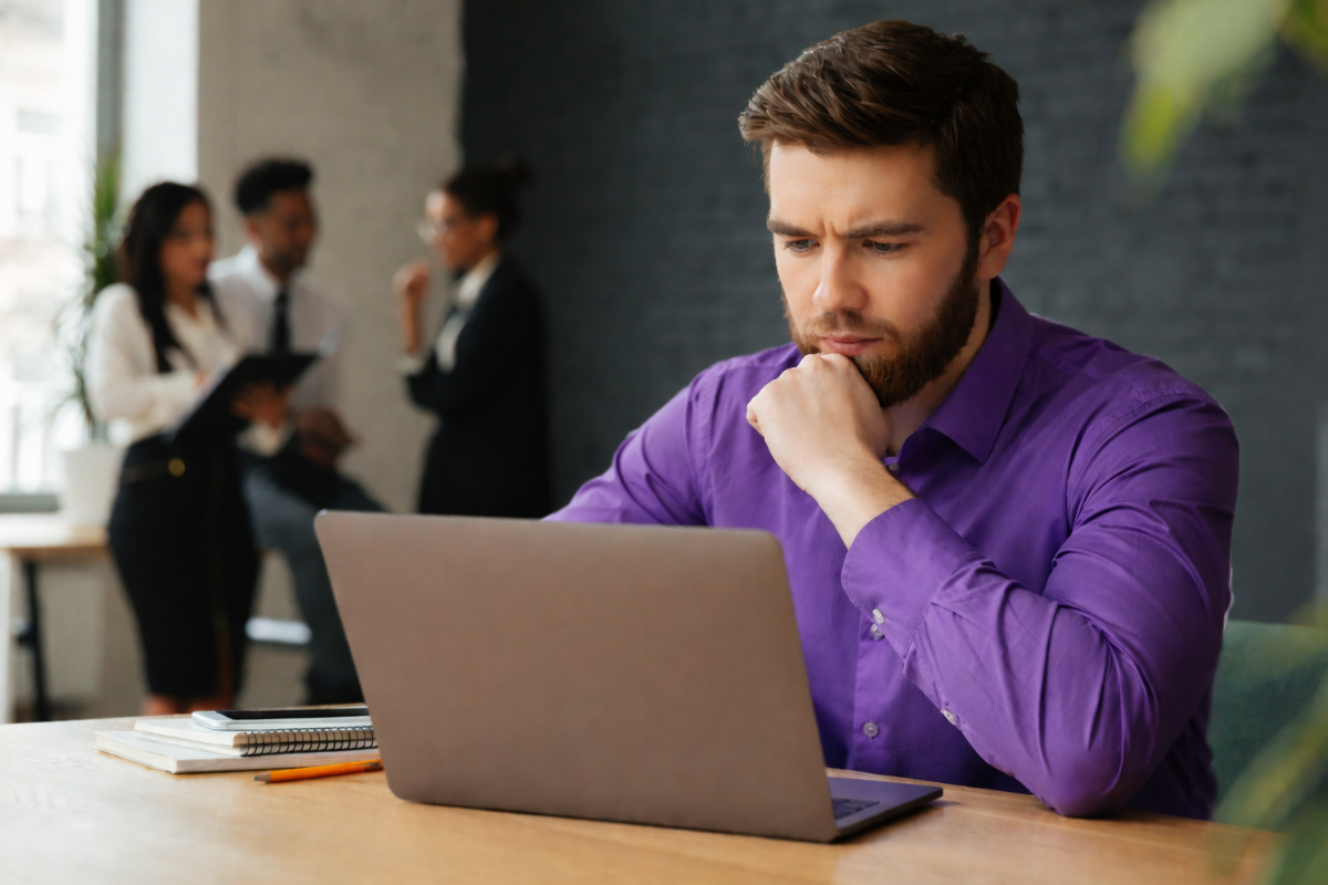 Homem profissional trabalhando em um notebook sobre uma mesa em um ambiente de escritório representando: Como saber se sua empresa precisa de um sistema de gestão.