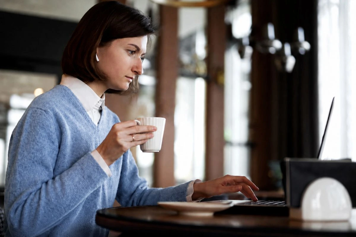 Mulher sentada em ambiente de escritório usando notebook para saber Como escolher um ERP adequado ao regime tributário da empresa.